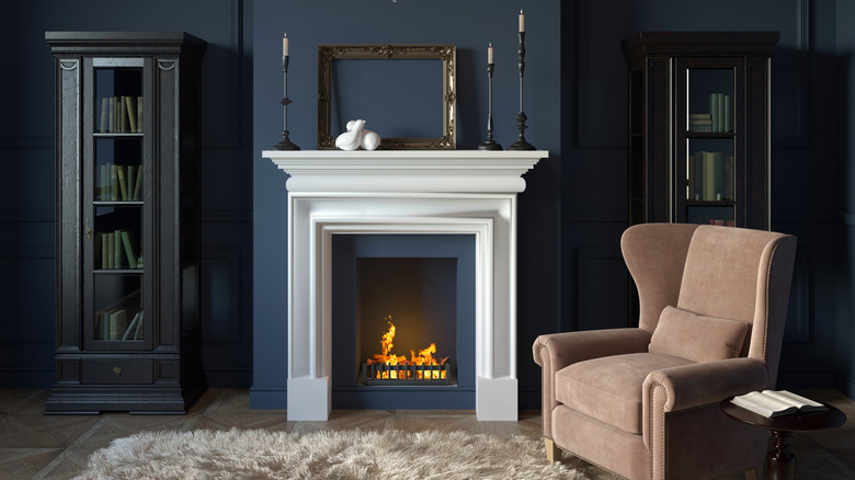 A living room with a teal wall behind the fireplace and accents painted in the fireplace.