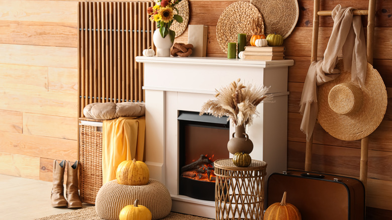 A fireplace with a wooden focal wall, storage rack and basket trivets hanging on the wall.
