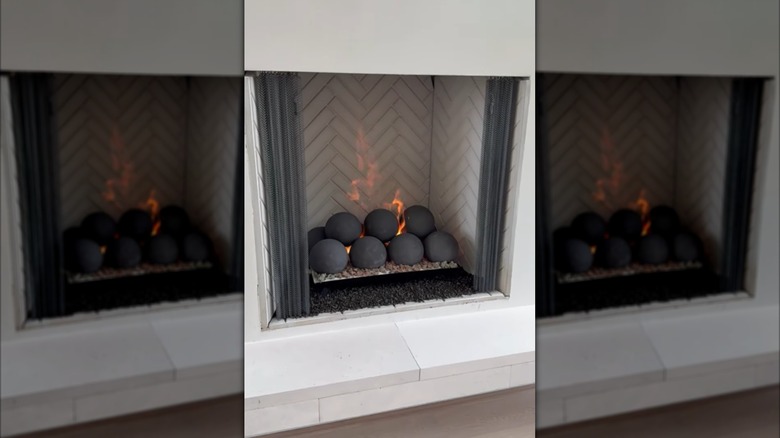A gray ceramic fireball set in a fireplace with a chevron patterned firebox.