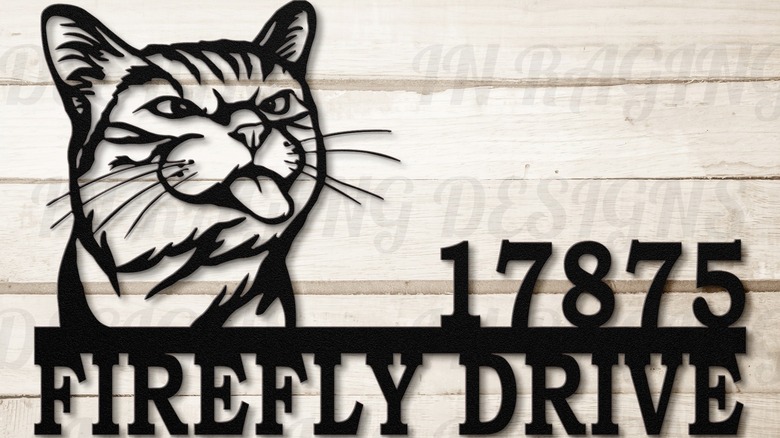 A house number with a cat sticking its tongue out