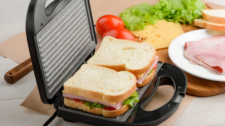 A fresh sandwich lying on an open sandwich press.
