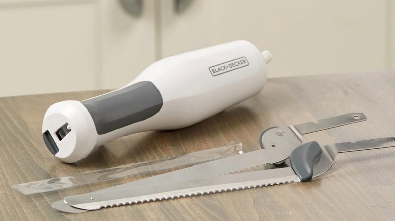 A disassembled electric carving knife on a kitchen counter.