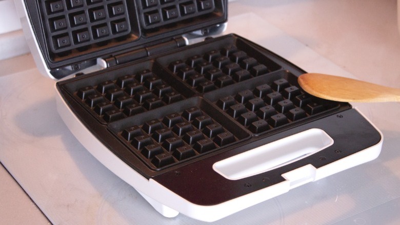 A clean waffle maker sitting on a kitchen counter