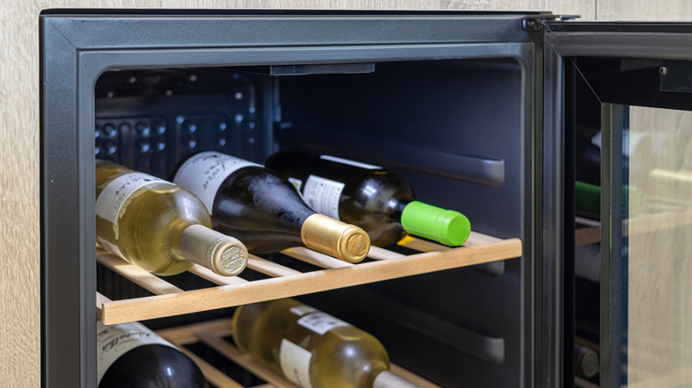 A wine fridge with bottles of wine lying on their sides.