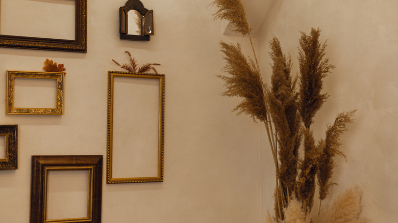 A gallery wall statement decor wall with empty gold frames.