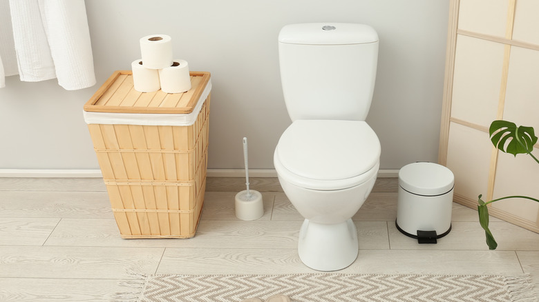 A bathroom with elegant, Asian-inspired accents and a monstera plant.