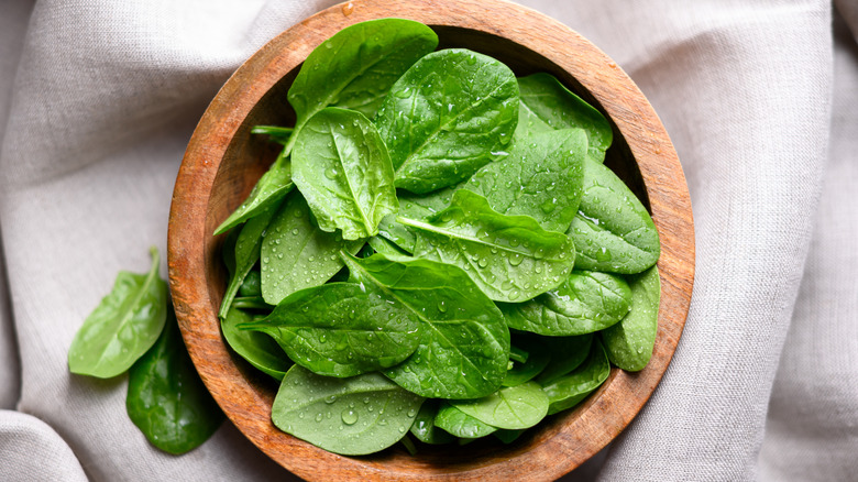 A bowl of wet washed spinach leaves