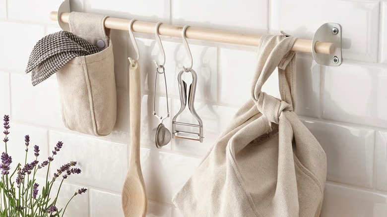 NEREBY birch wood rail, customized with white metal hooks, and beige cotton containers