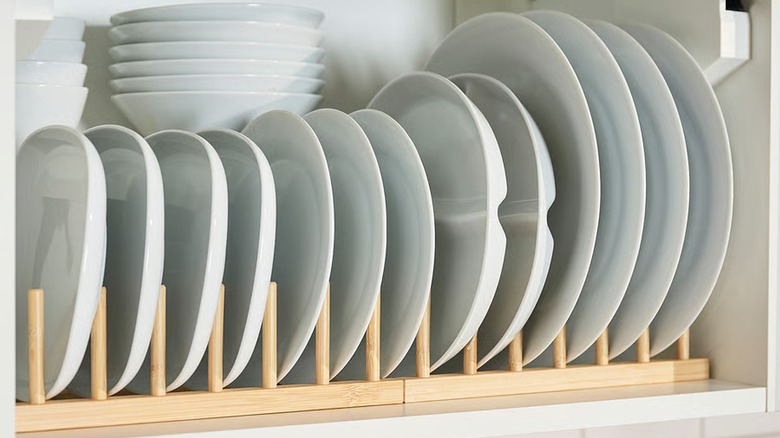 OSTBIT bamboo plate holder holding white plates inside kitchen cabinet