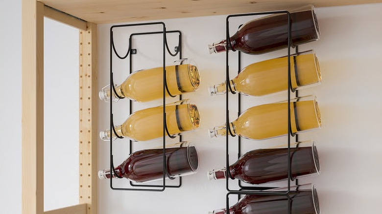 SNÖSPIRA black metal 4-bottle wine rack holding bottles full of juice