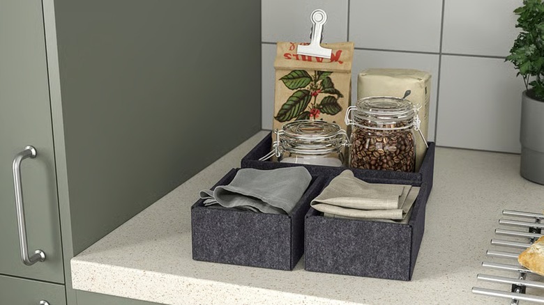 UPPDATERA polyester grey box carrying napkins and jars with tea, sugar, and coffee