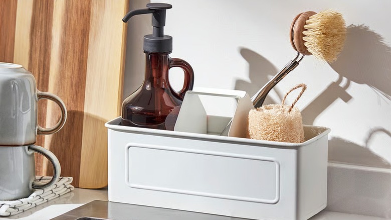 VÄLVÅRDAD white metal organizer with handle carrying a soap dispenser and brush