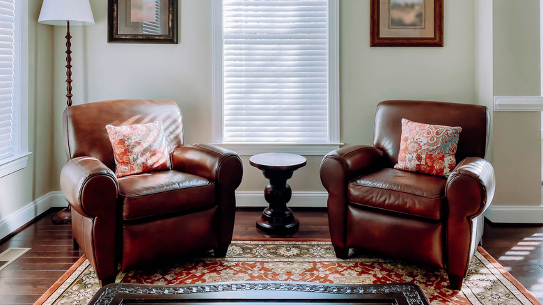 Two leather armchairs with throw pillows.