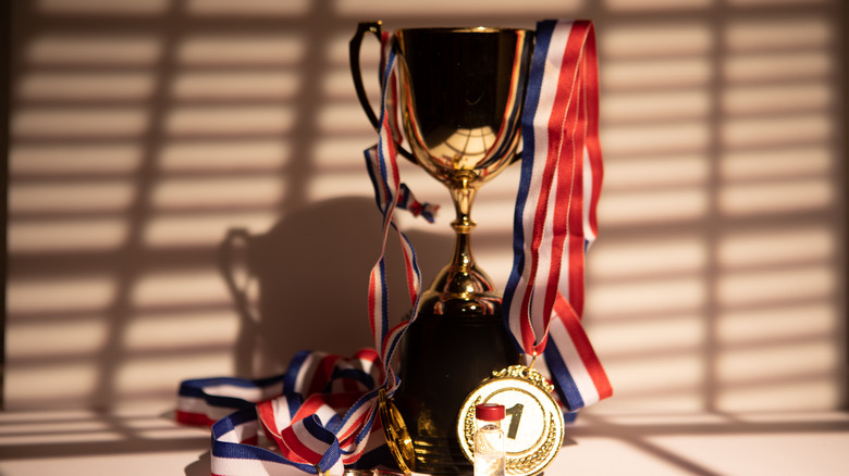 A trophy with multiple medals around it.
