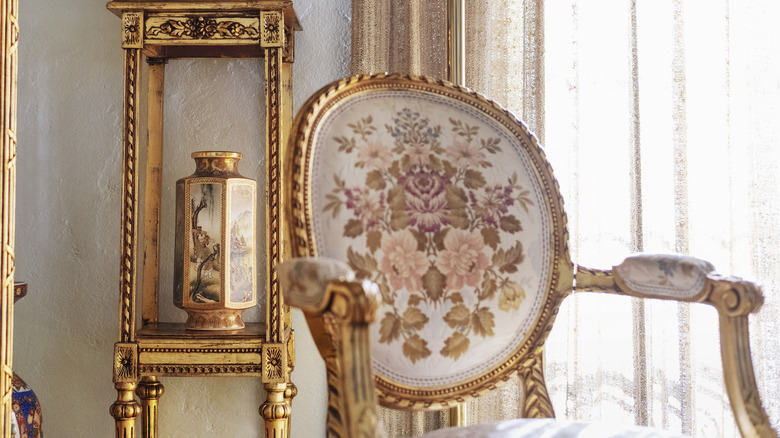 A vintage floral chair with gold accents.