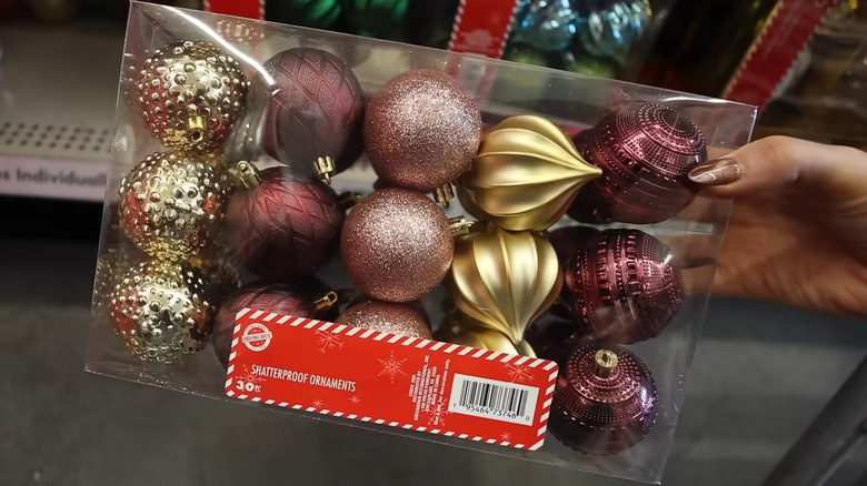 A box of red and gold Dollar Tree Christmas ornaments.