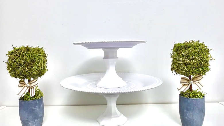 White two-tiered tray made from plates and glass candleholders