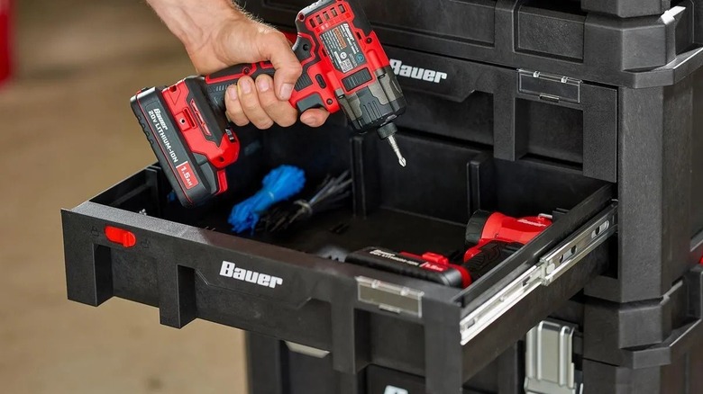 Person placing a drill in a toolbox