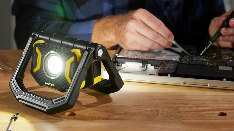 Person using a folding light on a workbench