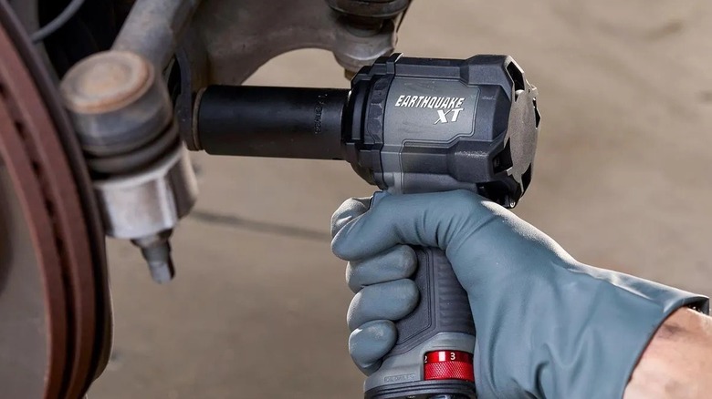 Person using an impact wrench on a car