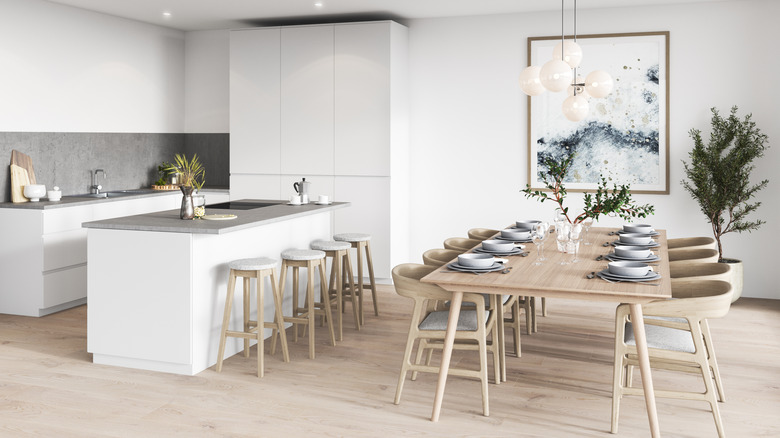 A modern kitchen with abstract wall art hanging near a dining table.