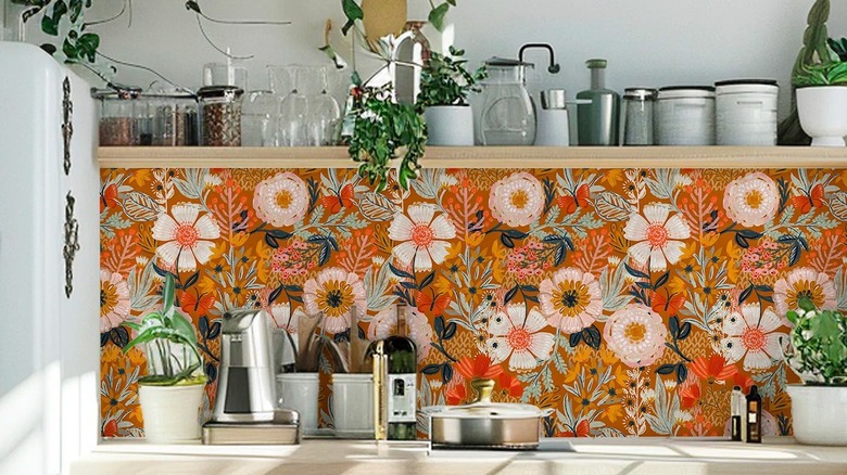 A kitchen wall with highly patterned floral wallpaper.