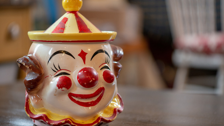 A vintage ceramic clown cookie jar with a hat for the lid.