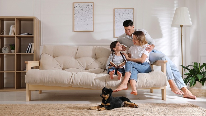 Family on sofa, reading book