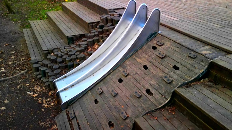 a slide, climbing wall, and climbing logs built into a stairway