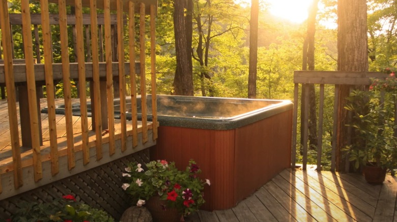 jacuzzi on a multi-level deck, overlooking a garden in glowing sunshine