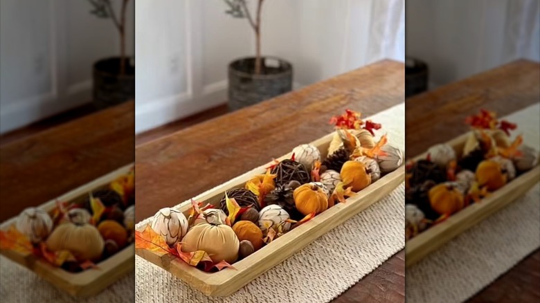 Dough bowl filled with vase filler, plush mini pumpkins and leaves