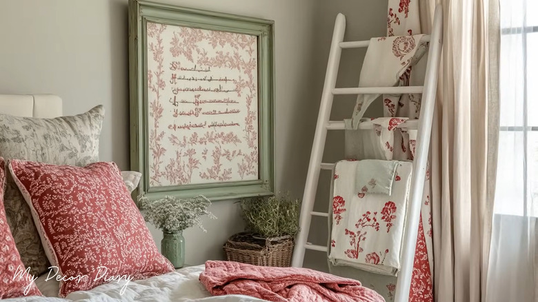 an old ladder has been painted and stands next to a bed to hold linens
