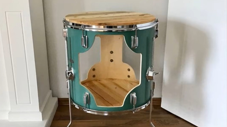 an old drum has been turned into a shelf that can easily fit in an empty corner of your living room