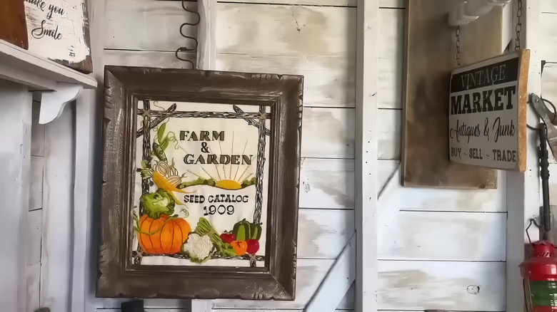 an embroidered garden design in a frame adds rustic charm to a corner