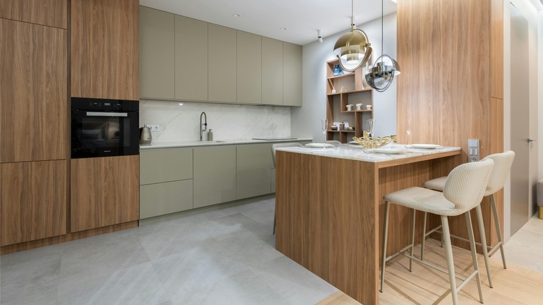 Warm, white oak cabinets in a modern style with a cool-toned gray tiled floor.