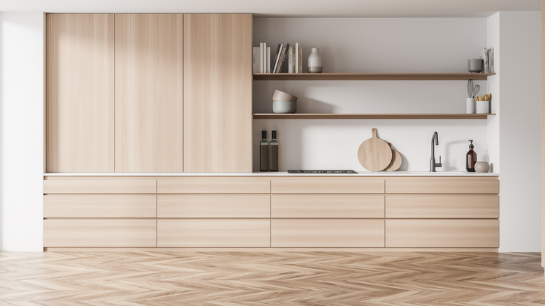 A living room with light white oak cabinets and wooden floors set in a herringbone pattern.