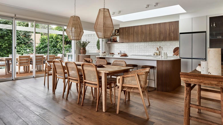An open concept kichen and dining space with cool toned white oak cabinets and reclaimed wood accents and flooring.