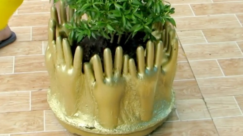 gold hand planter made from rubber gloves