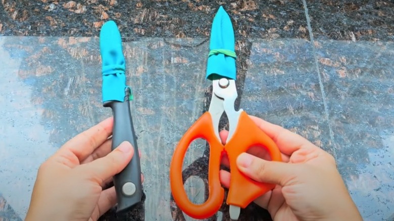 Scissor and utility knife blades covered with blue rubber glove material