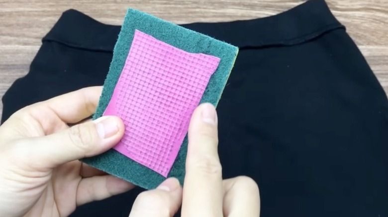 Piece of rubber glove attached to a dish sponge