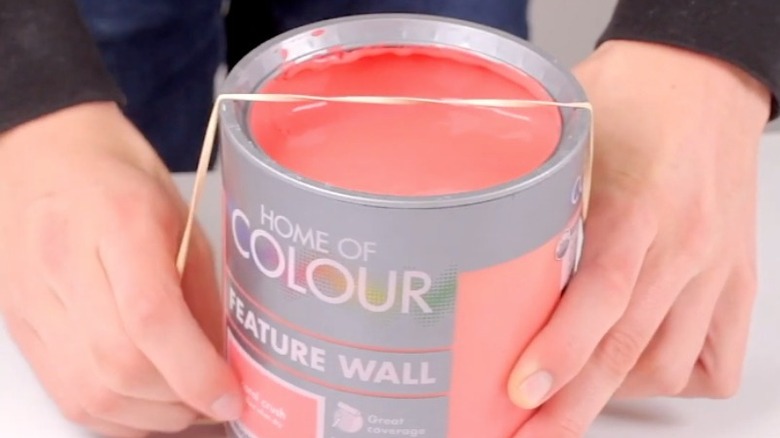 Paint can with rubber glove stretched over