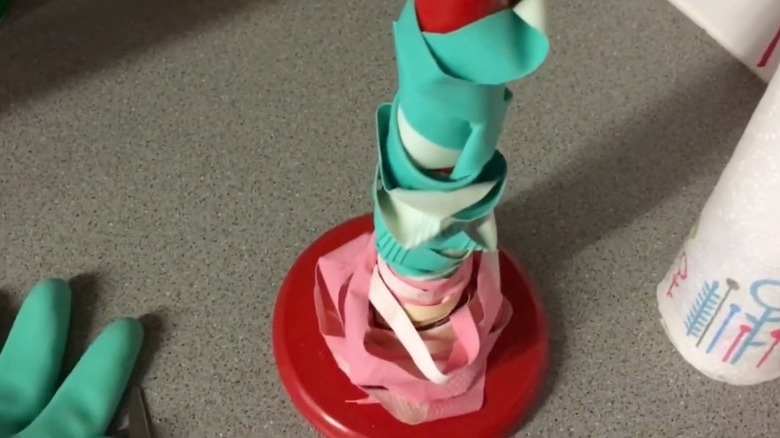 Paper towel roll holding DIY rubber bands from gloves
