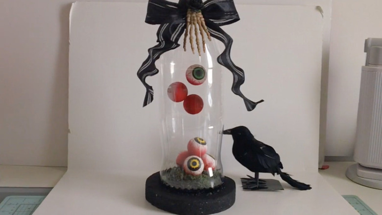 Dangling eyeballs in a glass cloche for Halloween
