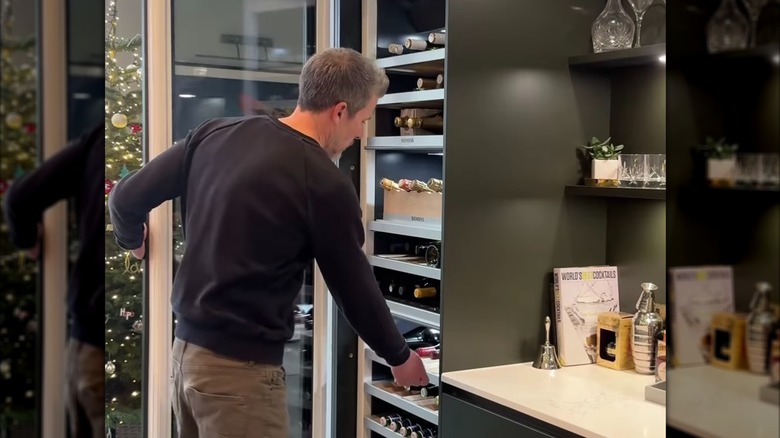 man opening custom wine fridge in luxury kitchen
