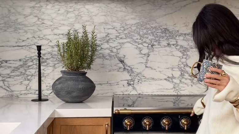 single marble slab backsplash in kitchen with woman standing in front