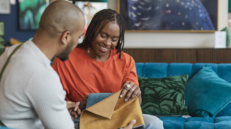 People looking through upholstery swatches in a furniture showroom