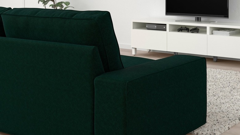 A dark green sofa facing a TV in a modern living room