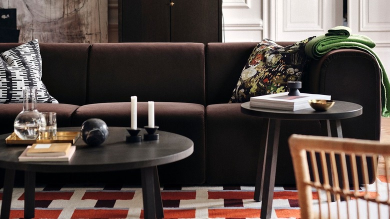 A brown sofa in a living room with patterned cushions