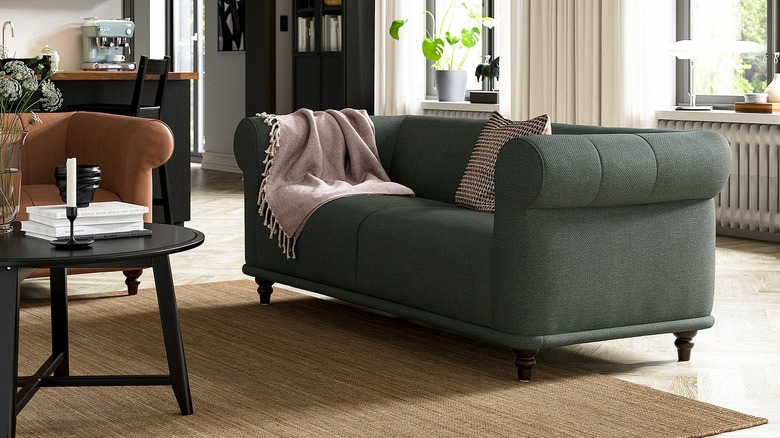 An elegant green sofa in a upscale living room with earthy tones