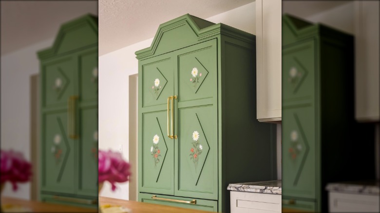green cabinet painted with subtle Scandinavian-inspired folk paint